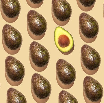 repeated avocado and one halved avocado fruit on the beige background