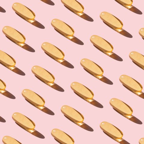 Repeated fish oil pills on pink background