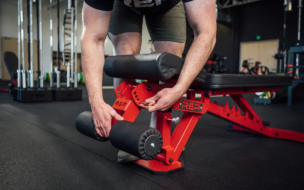 adjusting a benchs leg press attachment in a gym