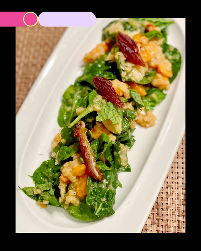 salad featuring spinach grains and dried fruits served on a white plate salad featuring spinach grains and dried fruits served on a white plate