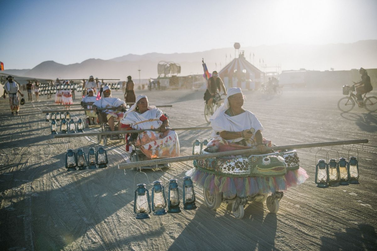 Leden van het Mobility Camp die dienst doen als lamplighters op Burning Man rijden door Black Rock City een uitgestrekte camping die als thuisbasis dient voor het woestijnfestival Lamplighters zorgen elke avond voor verlichting zodat mensen na zonsondergang naar hun kamp kunnen terugkeren