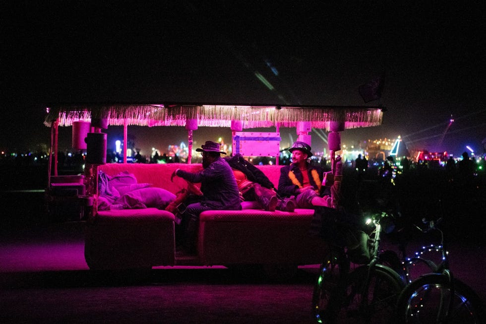 Twee bezoekers delen een rustig moment in een versierd voertuig op Burning Man