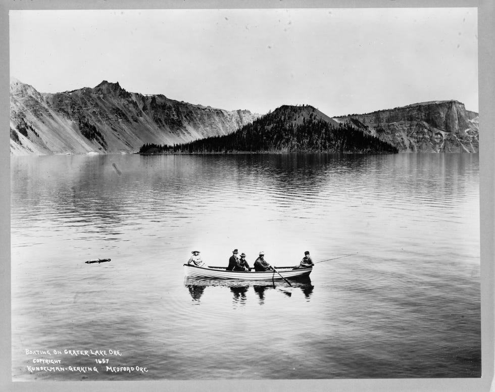 Crater Lake, Circa 1912 Bezoekers aan het Crater Lake in Oregon nemen het ervan in een boot in de buurt van Wizard Island een klassieke sintelkegel die zijn naam te danken heeft aan zijn gelijkenis met een tovenaarshoed Het Crater Lake is met zijn 630 meter het diepste meer in de Verenigde Staten Het bevindt zich in Mount Mazama een slapende vulkaan in de Cascades