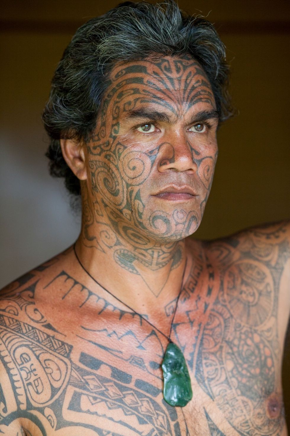 Een man met een typisch Polynesische tattoo over zijn hele lichaam en gezicht in Moorea FransPolynesi