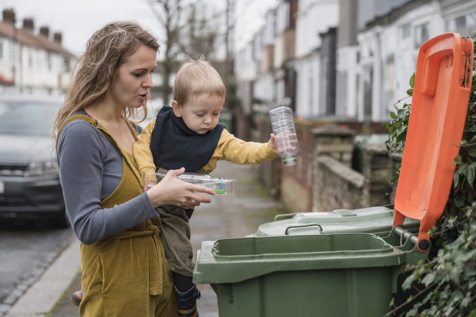 madre enseñando a su hijo pequeño a reciclar