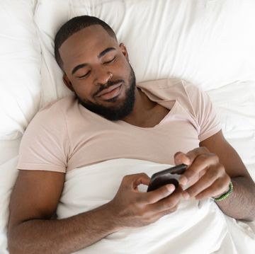 rested african american man waking up at comfortable bed