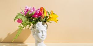 retro head sculpture with flowers on beige background