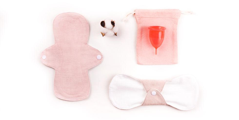 reusable cloth menstrual pads and menstrual cup on white background