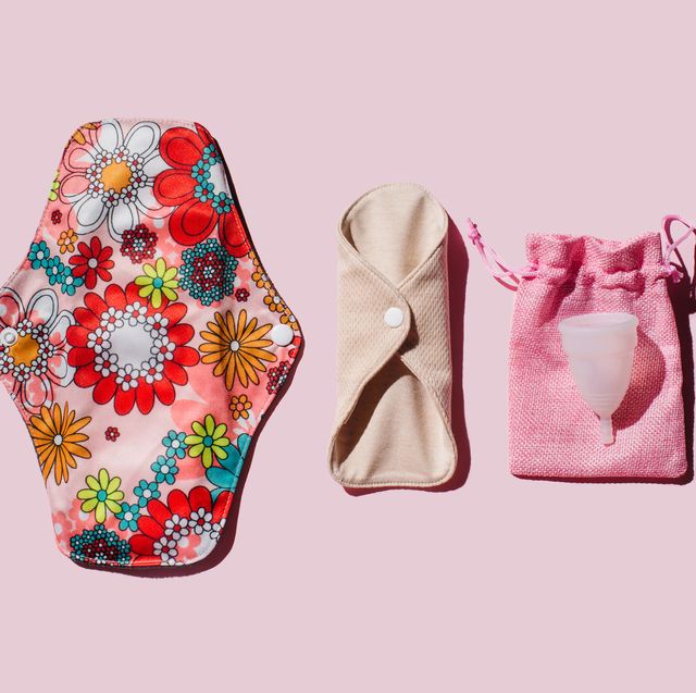 reusable cloth menstrual pads and menstrual cup on pink background
