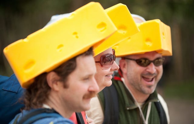Revellers in cheese-shaped hats arrive a