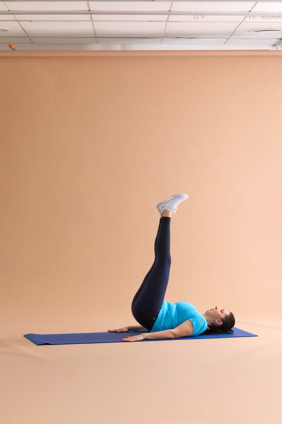 a person performing a leg raise exercise on a yoga mat