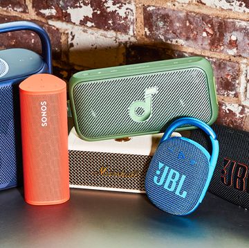 a group of bluetooth speakers against a brick wall