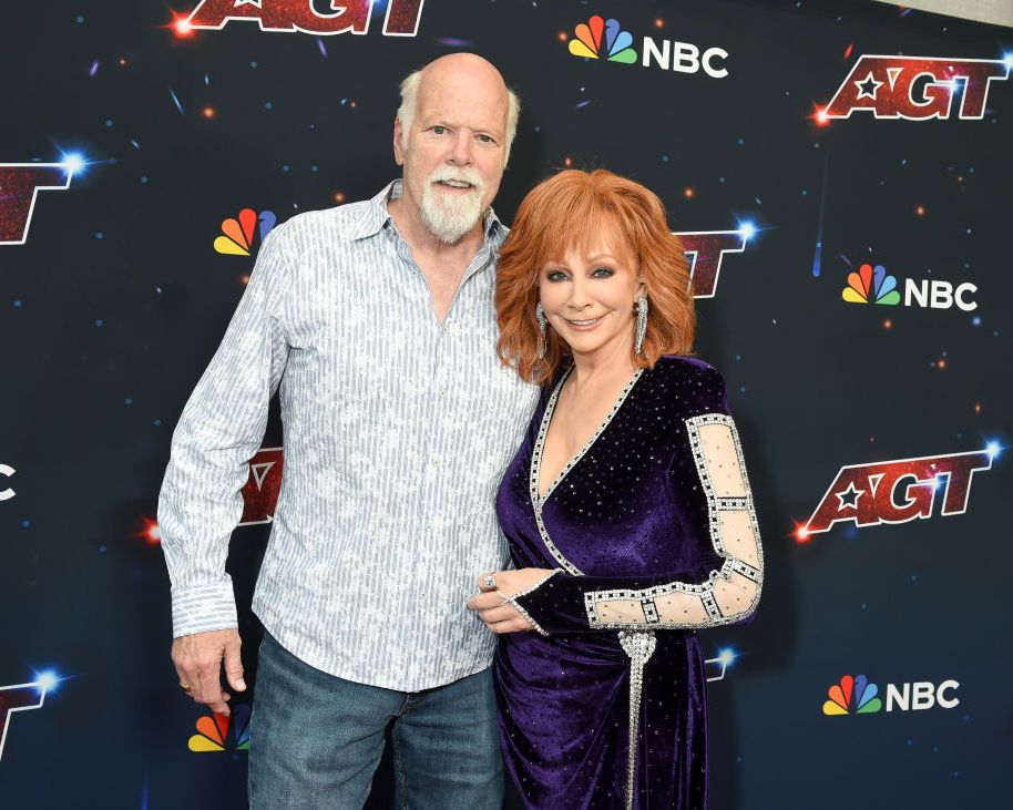 reba mcentire and rex linn embracing and smiling for a red carpet photo