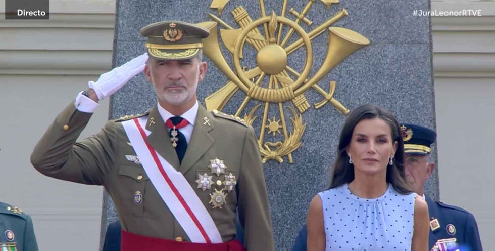a man in uniform standing next to a woman in a dress