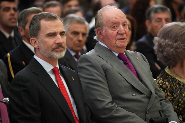rey juan carlos y el rey felipe vi sentados y serios