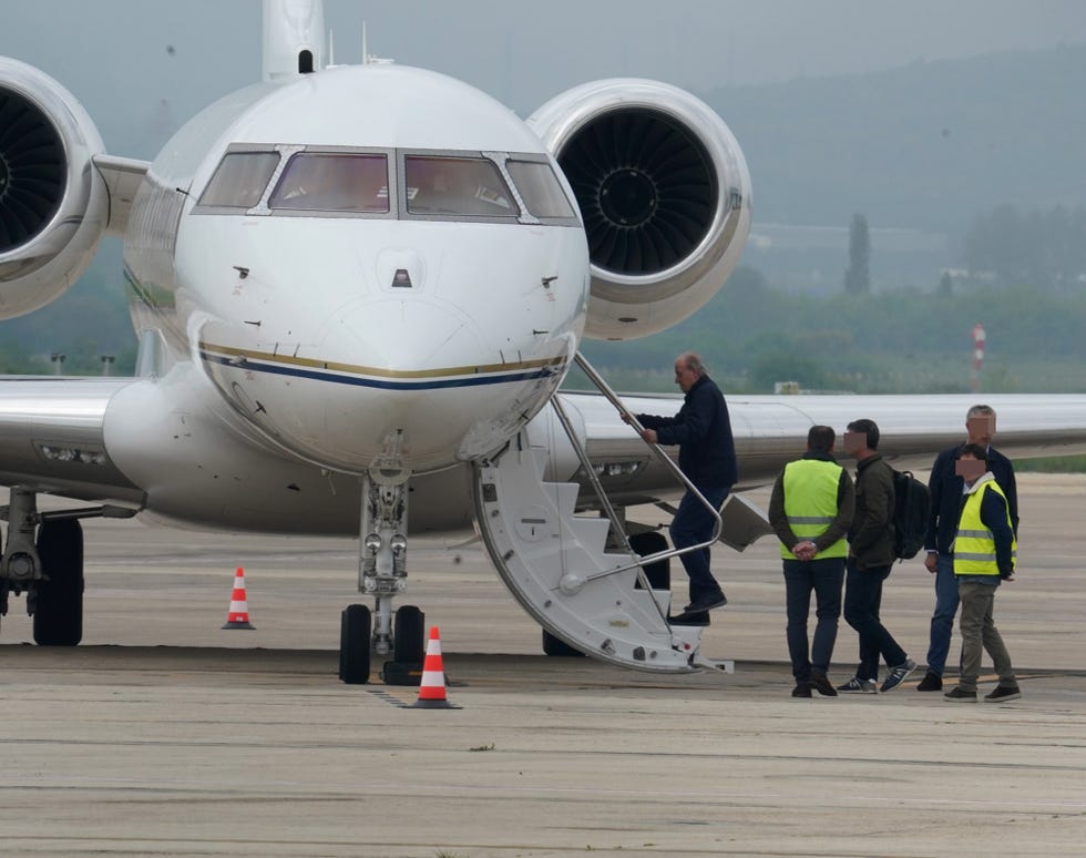 el emerito sube la escalerilla de un avion privado
