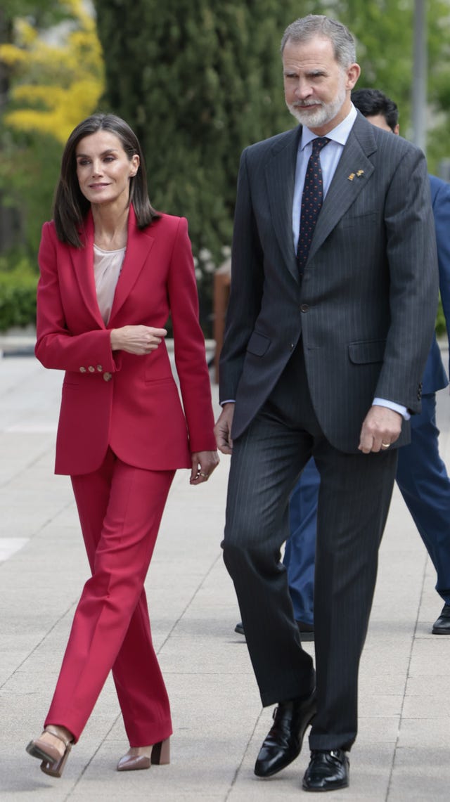 letizia, con un traje rojo, y felipe vi con un traje de rayas