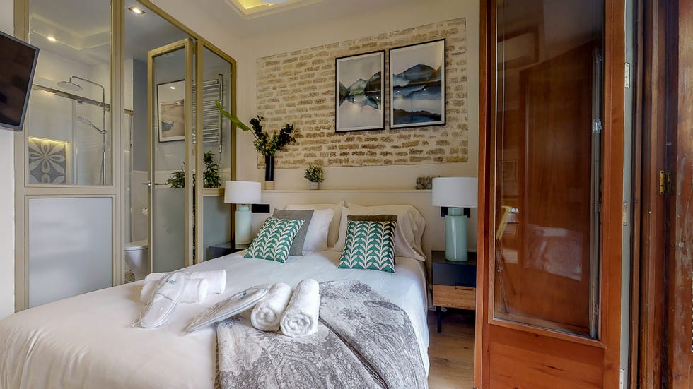 dormitorio con baño en suite con cerramiento de vidrio