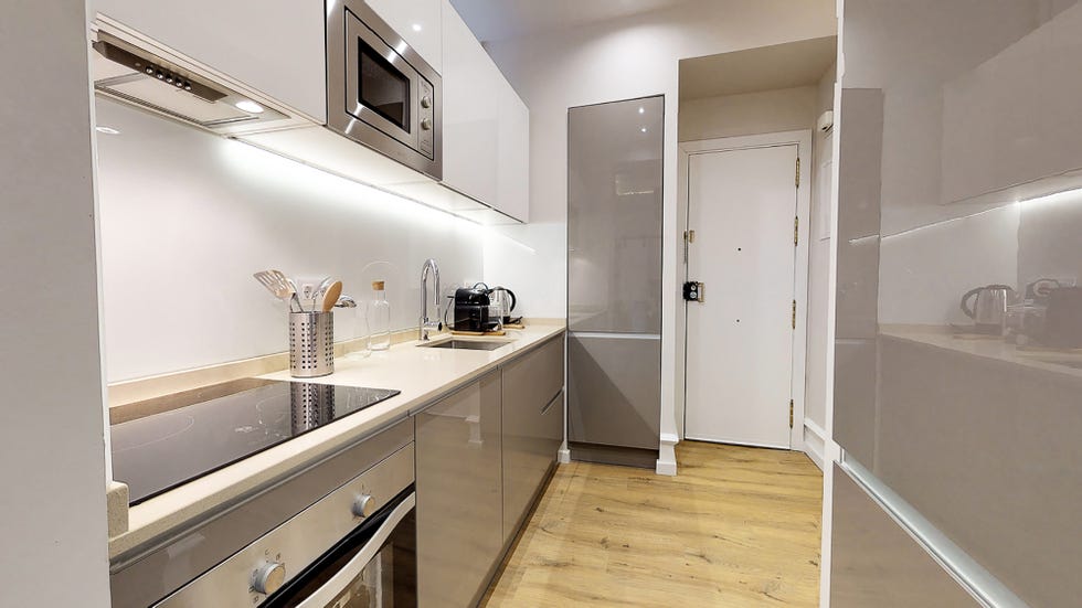 cocina moderna con armarios lacados en gris y suelo de tarima
