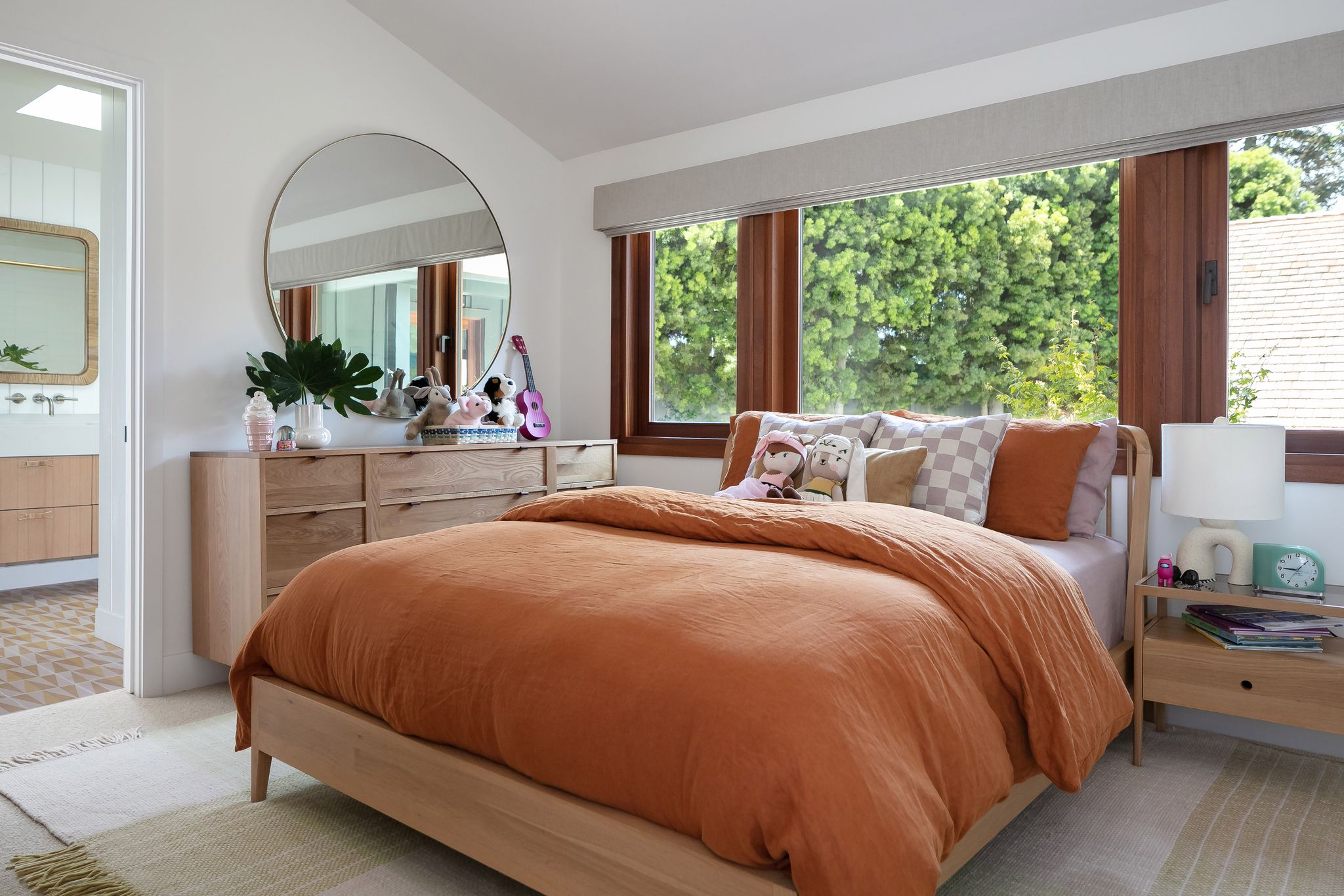 bedroom with large windows and orange linens