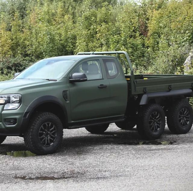 a dark green ford ranger pickup with a 6x6 layout sits on a gravel road in front of some shrubs