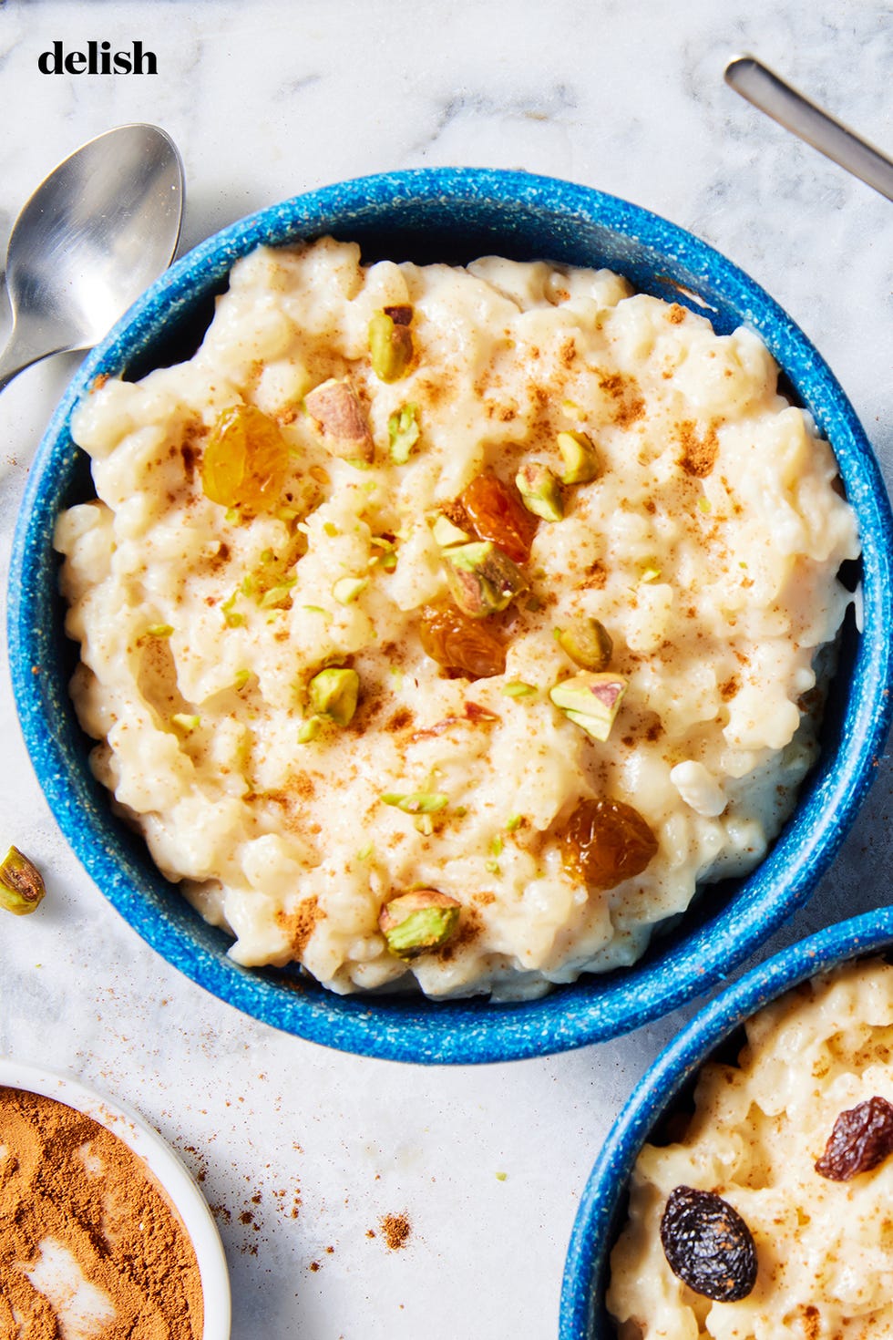 rice pudding in a blue bowl with pistachios and toppings