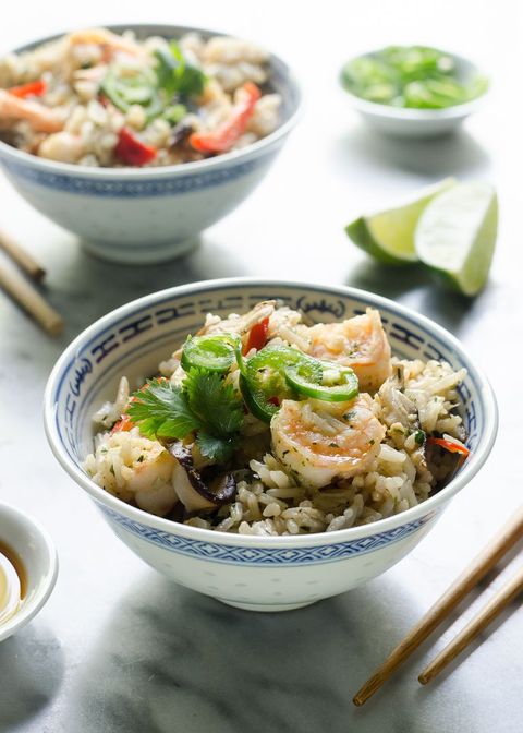 one pot shrimp and coconut rice with chopsticks and lime wedges
