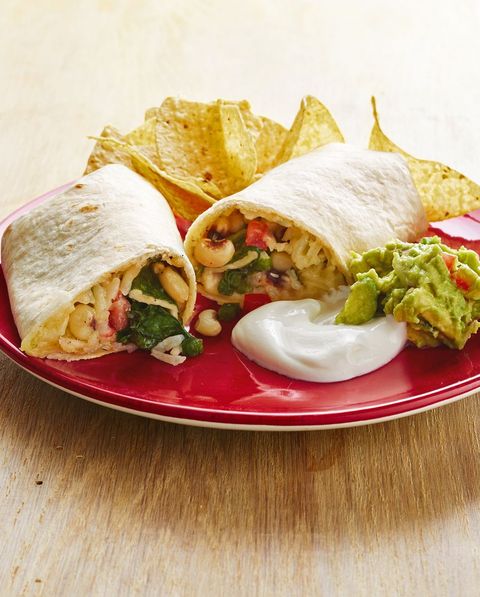 veggie burritos with black eyed peas chips and guacamole on plate