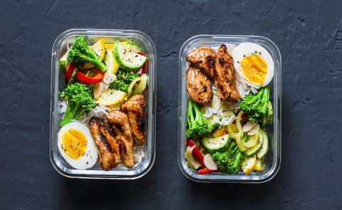Rice, stewed vegetables, egg, teriyaki chicken - healthy balanced lunch box on a dark background, top view. Home food for office concept