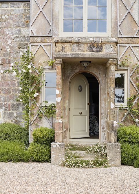 a rounded top door opens to the manor house with a stone exterior