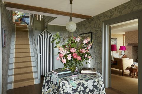 a victorian tented wardrobe brings a carnivalesque sense of whimsy to the entry with black and white stripes and floral table cloth