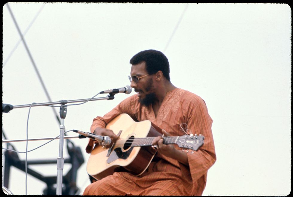Richie Havens performs onstage at the Woodstock Music and Arts Fair in Bethel, New York, August 15, 1969