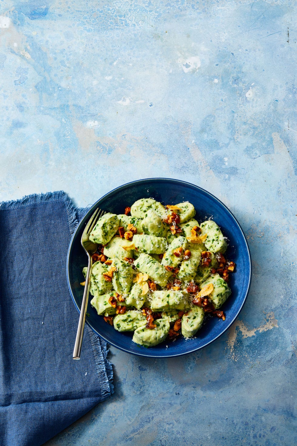 ricotta gnocchi with toasted garlic and walnuts in a blue bowl