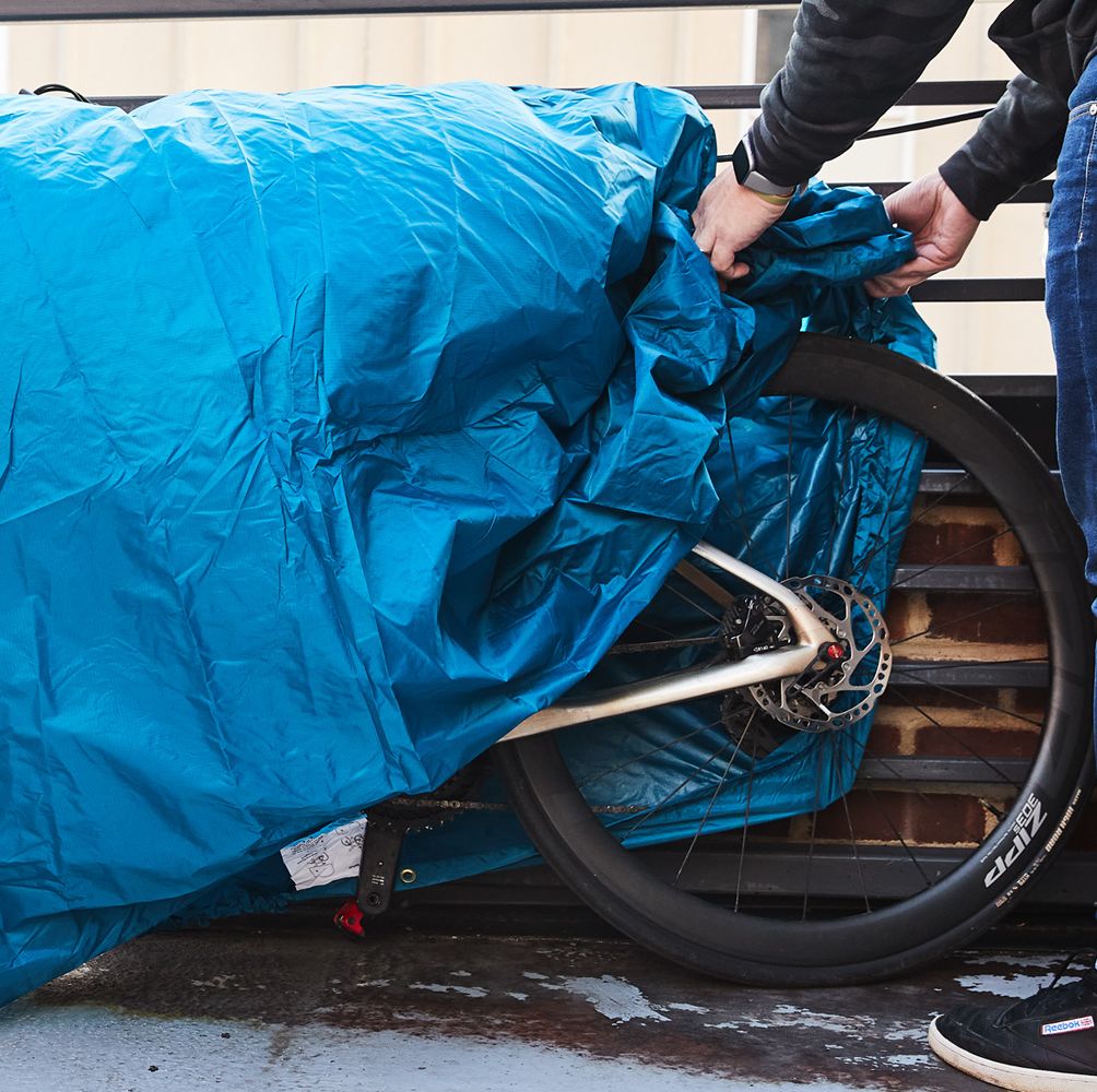 a person covering a bicycle