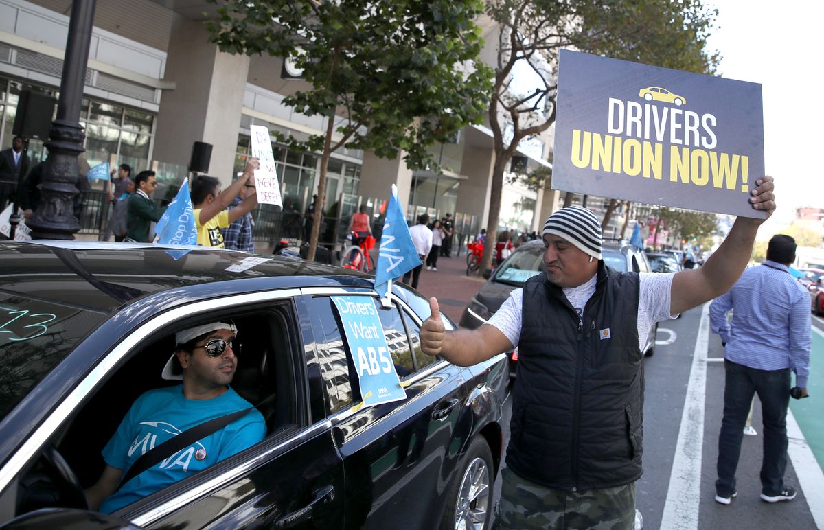 Ride-share drivers and supporters protest outside Uber headquarters in support of the bill.