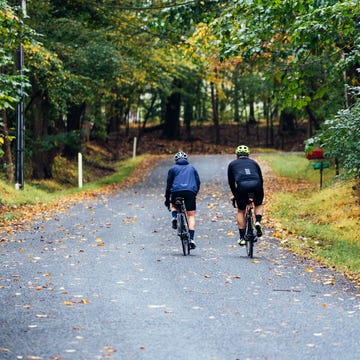 two cyclists riding together up a hill