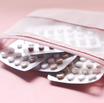 birth control pills on pink background, close up