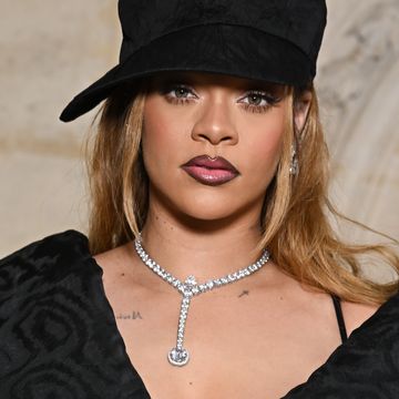 rihanna in a black hat and black outfit with blonde hair