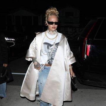 rihanna leaving a restaurant in los angeles wearing a white satin coat on top of a white top jeans and black sunglasses