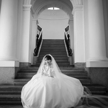 ウエディングドレスをまとい、階段に座るモノクロの花嫁フォト