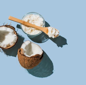 ripe coconuts, coconut oil on blue background health and wellness concept minimal flat lay style top view, copy space