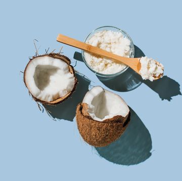 ripe coconuts, coconut oil on blue background health and wellness concept minimal flat lay style top view, copy space