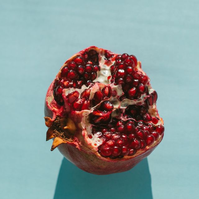 ripe halved fresh pomegranate in bright sunlight