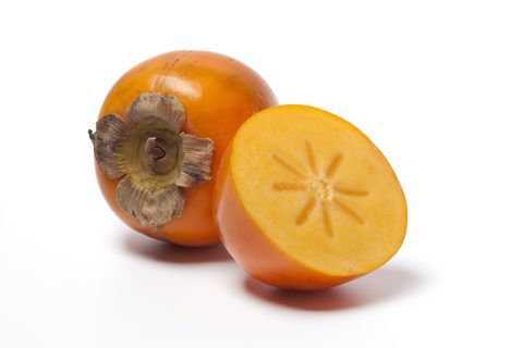 Ripe orange persimmon against white background