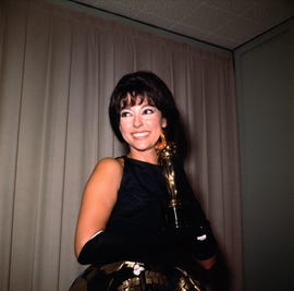 rita moreno smiling as she holds her academy award