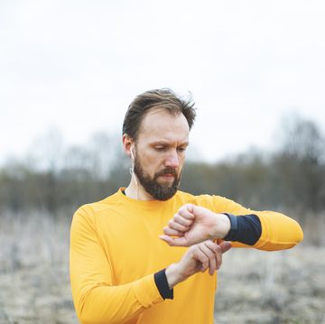 un corredor controla en su smartwatch las pulsaciones y el ritmo cardiaco de su carrera