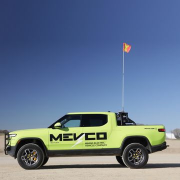 a green rivian with a flag on top of it