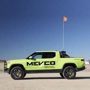 a green rivian with a flag on top of it