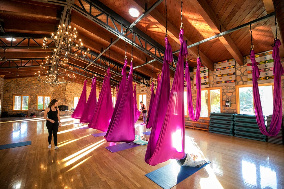 aerial yoga studio with suspended hammocks and participants engaged in practice