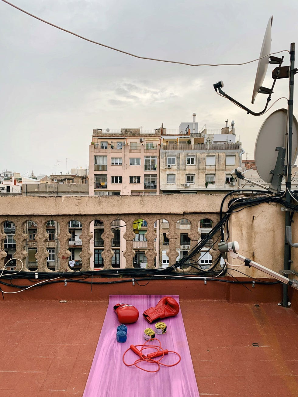 BARCELONA, SPAIN BARCELONA SPANJE Een fotograaf is 24 uur per dag en het hele jaar door fotograaf niet alleen als hij of zij aan een reportage werkt zegt Paolo Verzone die de gemproviseerde fitnessruimte vastlegde die hij op zijn dak in Barcelona heeft ingericht Ik voel me prima bij het documenteren van mijn zelfisolatie In mijn keuken of in een kamertje van twintig vierkante meter Het is alsof ik ergens midden in een woestijn met een prachtig uitzicht zit